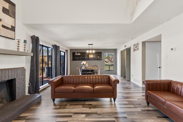 living room featuring a brick fireplace and wood finished floors