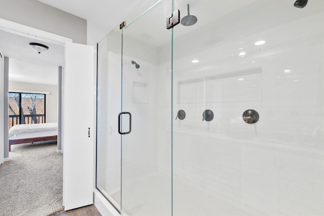 ensuite bathroom with a shower stall, connected bathroom, and recessed lighting