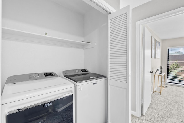 laundry area with baseboards, laundry area, light colored carpet, and washer and dryer