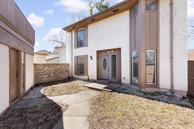 exterior space featuring fence and stucco siding