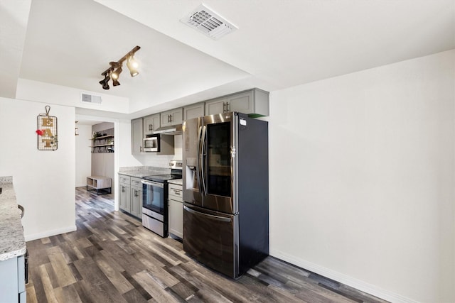 kitchen with a tray ceiling, appliances with stainless steel finishes, gray cabinets, and visible vents