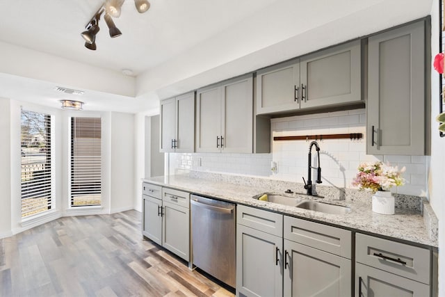 kitchen featuring a sink, stainless steel dishwasher, gray cabinets, and visible vents