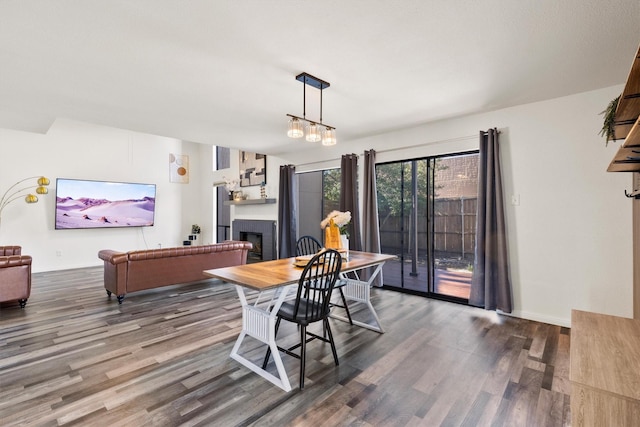 dining space with a fireplace, wood finished floors, and baseboards