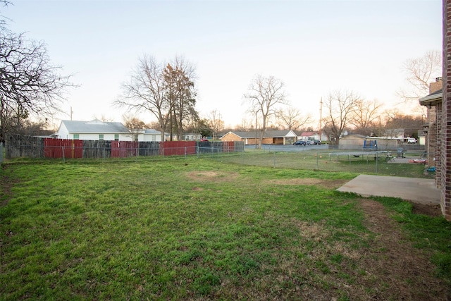 view of yard with a trampoline and fence