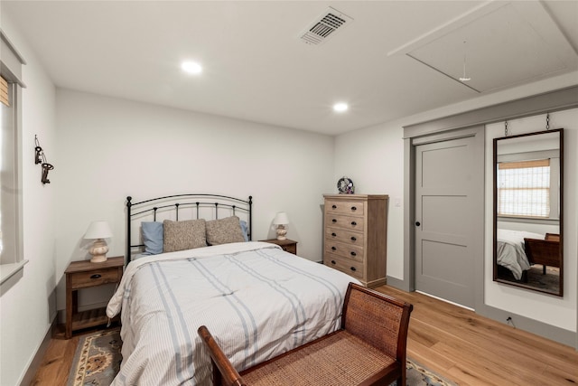 bedroom featuring attic access, visible vents, light wood-style flooring, and recessed lighting