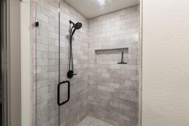 bathroom with a stall shower and a textured wall