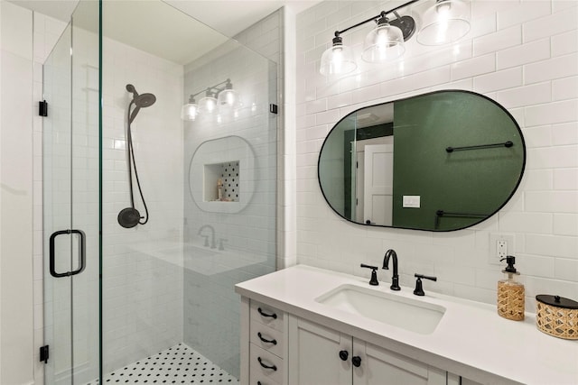 full bathroom featuring a shower stall, backsplash, tile walls, and vanity