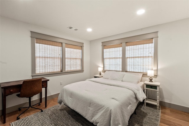 bedroom featuring recessed lighting, visible vents, baseboards, and wood finished floors