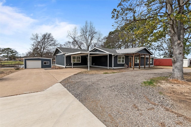 view of front of house featuring driveway, a carport, covered porch, an outdoor structure, and board and batten siding