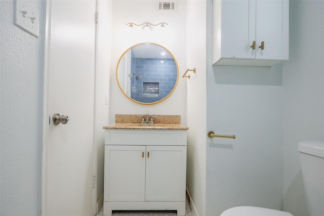 bathroom with toilet, visible vents, and vanity