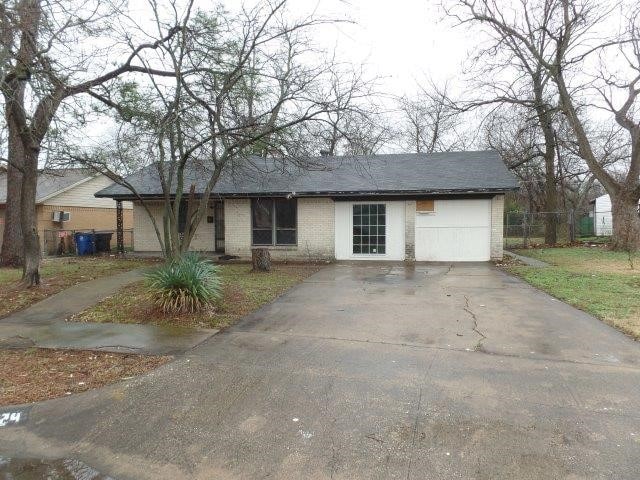 single story home featuring brick siding, driveway, and an attached garage