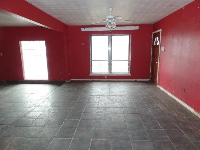 spare room featuring a ceiling fan and baseboards