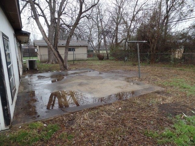 view of yard with a patio area, a fenced backyard, and central AC unit