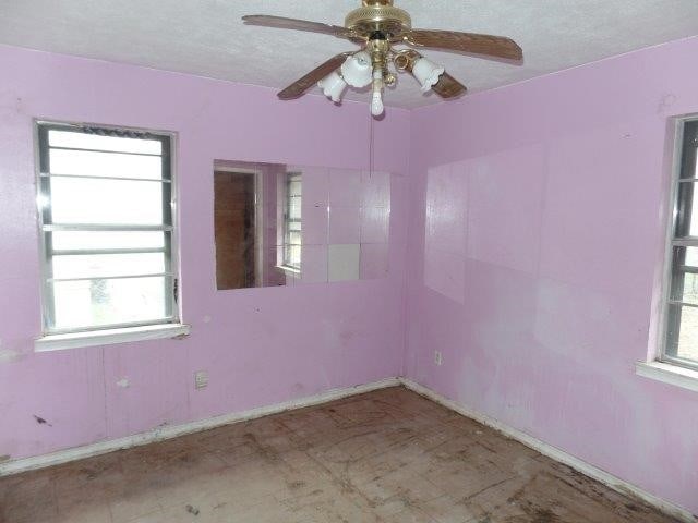 spare room with a ceiling fan and a textured ceiling