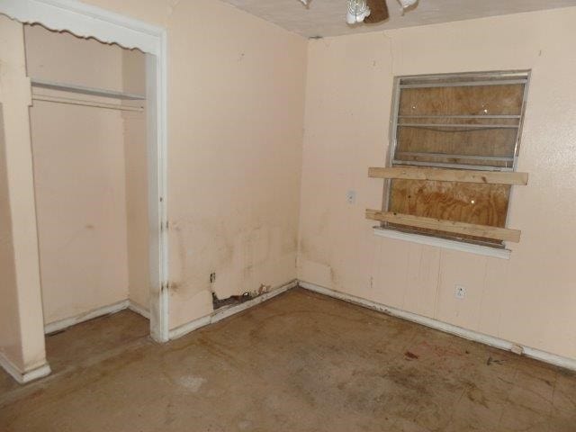 unfurnished bedroom featuring a closet and unfinished concrete flooring