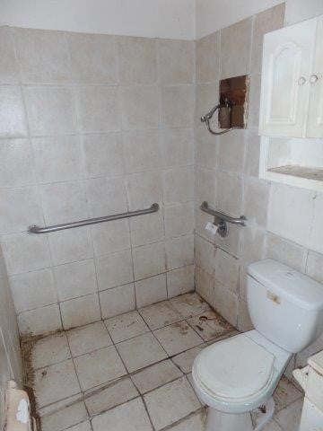 bathroom with toilet and tiled shower