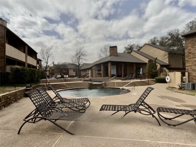 view of swimming pool featuring central AC and a patio