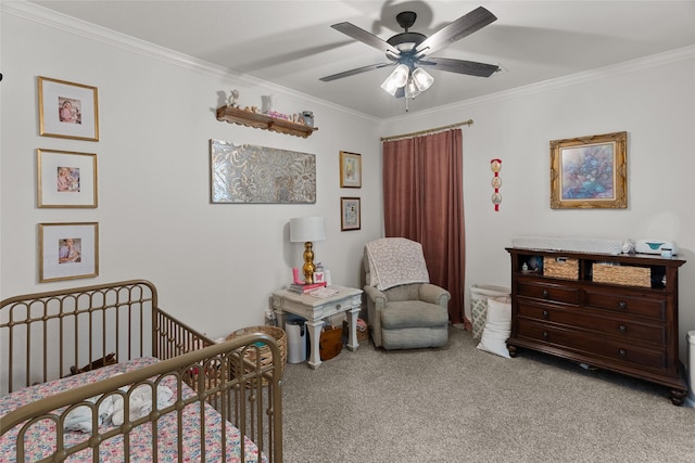 carpeted bedroom featuring a crib, a ceiling fan, and crown molding