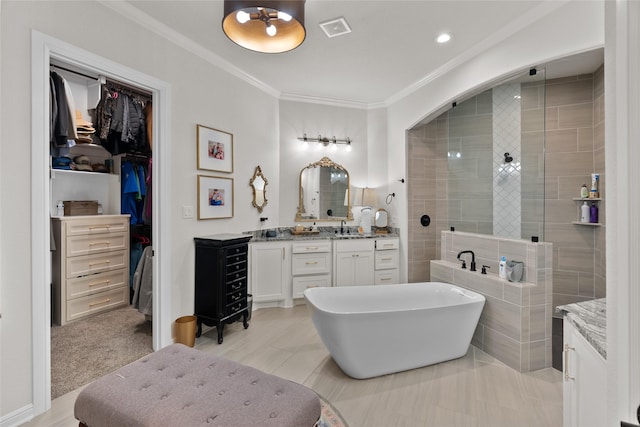 bathroom with a walk in closet, visible vents, ornamental molding, vanity, and tiled shower