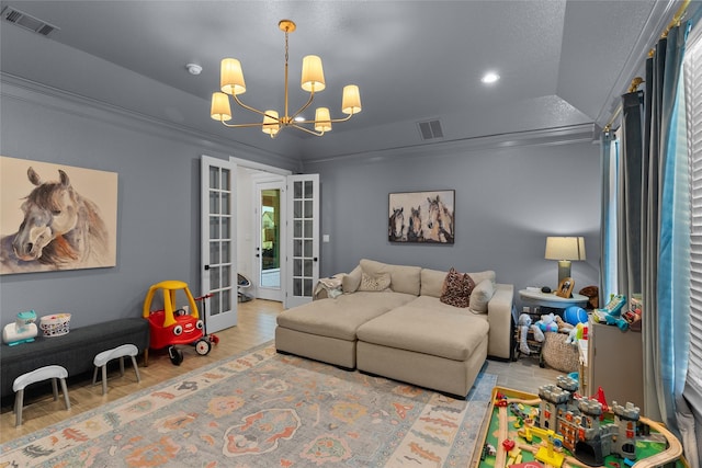 living room featuring wood finished floors, french doors, visible vents, and an inviting chandelier