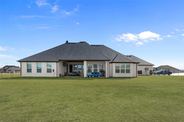 rear view of house with a patio area, roof with shingles, fence, and a yard