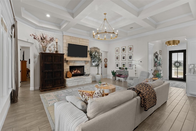 living room featuring coffered ceiling, beam ceiling, light wood-style floors, a fireplace, and a notable chandelier