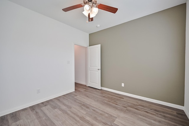 empty room featuring ceiling fan, baseboards, and wood finished floors