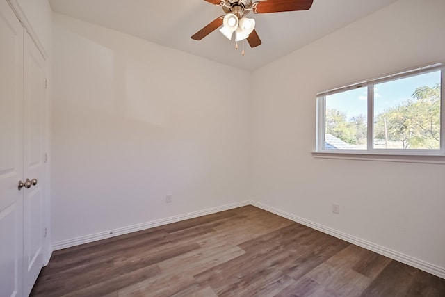 empty room featuring wood finished floors, a ceiling fan, and baseboards