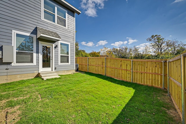 view of yard with entry steps and a fenced backyard