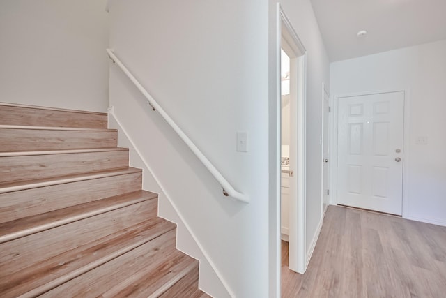 staircase with wood finished floors and baseboards