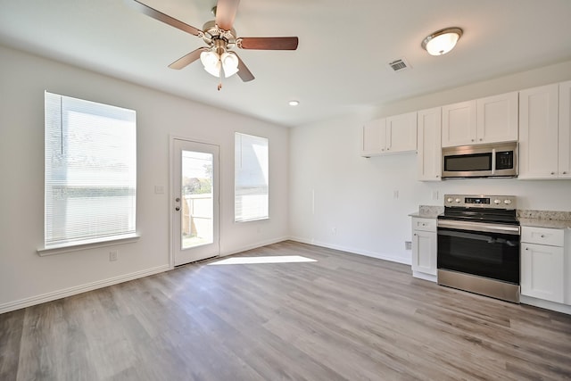 kitchen with visible vents, baseboards, appliances with stainless steel finishes, light wood-type flooring, and white cabinetry