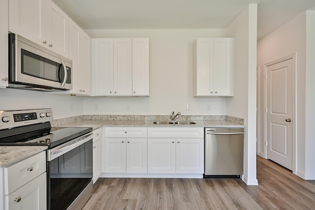 kitchen featuring stainless steel appliances, white cabinets, and a sink