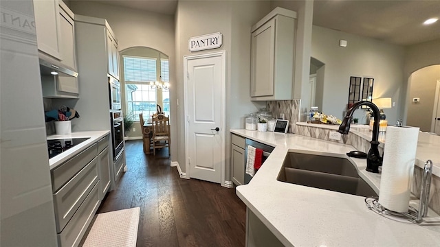 213 Stuart St, Paradise, TX 76073 - kitchen featuring dark wood finished floors, stainless steel appliances, arched walkways, light countertops, and a chandelier