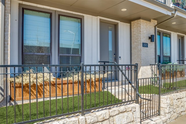 entrance to property with fence and brick siding