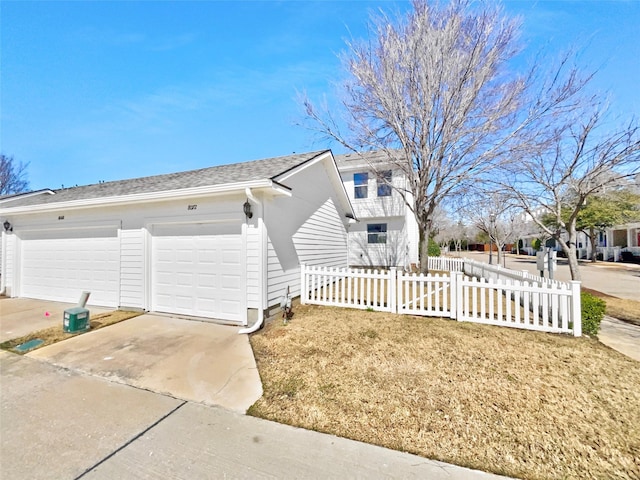 view of home's exterior with concrete driveway, roof with shingles, and fence