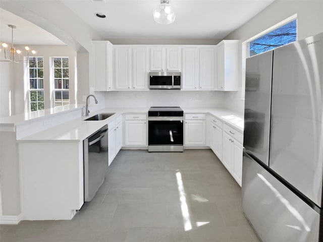 kitchen featuring stainless steel appliances, light countertops, a sink, and tasteful backsplash