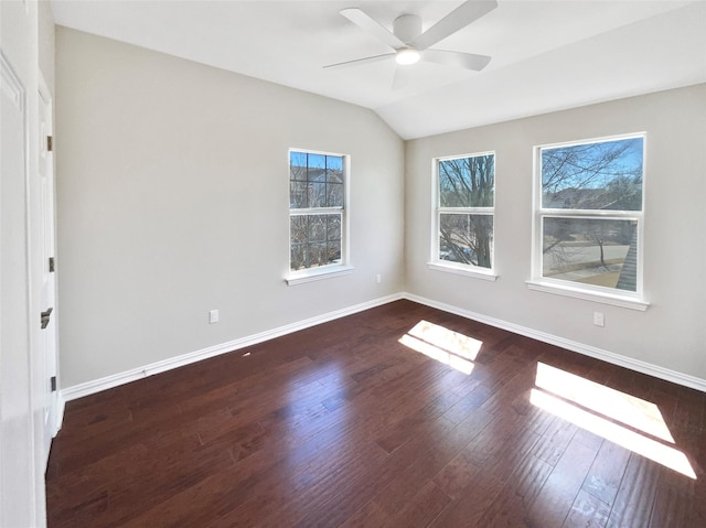 empty room featuring lofted ceiling, ceiling fan, wood finished floors, and baseboards