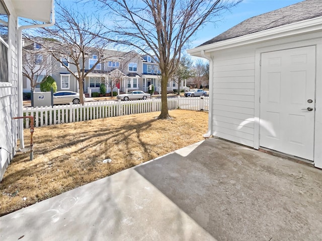 view of yard featuring a residential view, a patio area, and fence