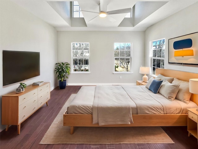 bedroom with ceiling fan, baseboards, and dark wood-style flooring