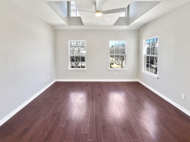 empty room featuring baseboards, dark wood-type flooring, and a ceiling fan