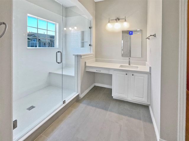 full bathroom with a shower stall, vanity, and baseboards