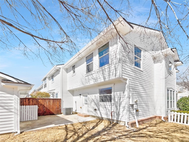 rear view of property featuring central air condition unit, a patio area, and fence