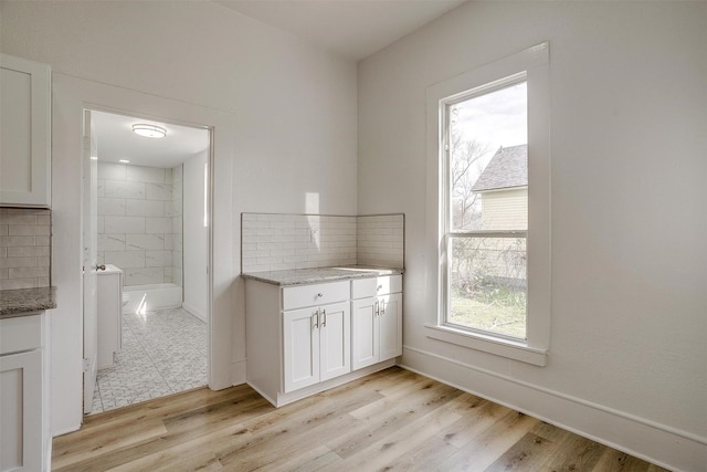 full bathroom featuring tasteful backsplash, a tile shower, vanity, and wood finished floors