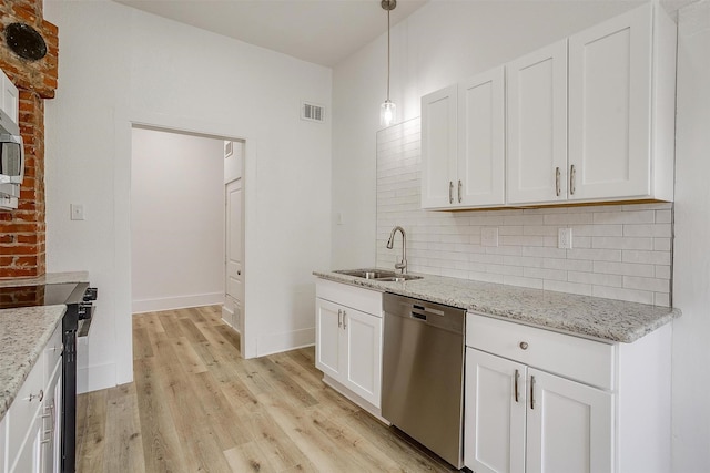 kitchen with stainless steel appliances, a sink, visible vents, light wood-type flooring, and backsplash