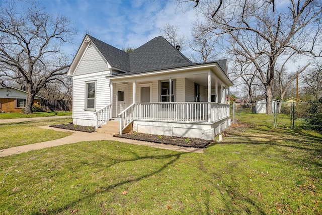 view of front facade featuring a porch, roof with shingles, a front yard, and fence