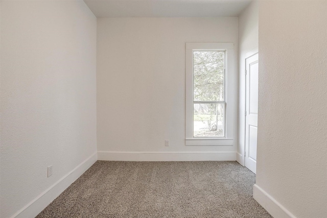 carpeted spare room featuring baseboards