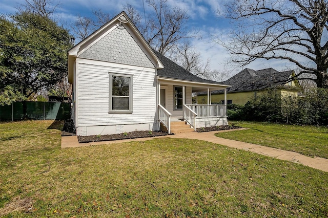 view of front of house featuring a porch, a shingled roof, crawl space, fence, and a front lawn