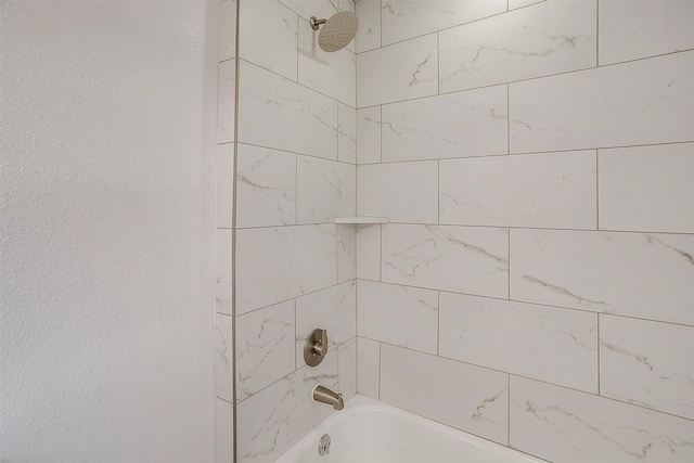 room details with a textured wall and shower / washtub combination