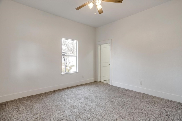 spare room with ceiling fan, carpet, and baseboards