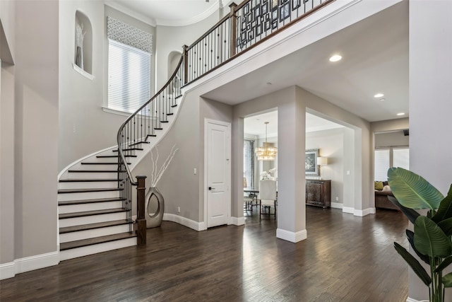 entryway with recessed lighting, a high ceiling, wood finished floors, baseboards, and stairway